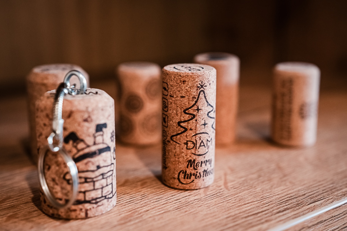 Porte-clés en bouchon de liège décoré (cheminée) et bouchon de Noël avec sapin et le texte "Merry Christmas DIAM" sur bois.